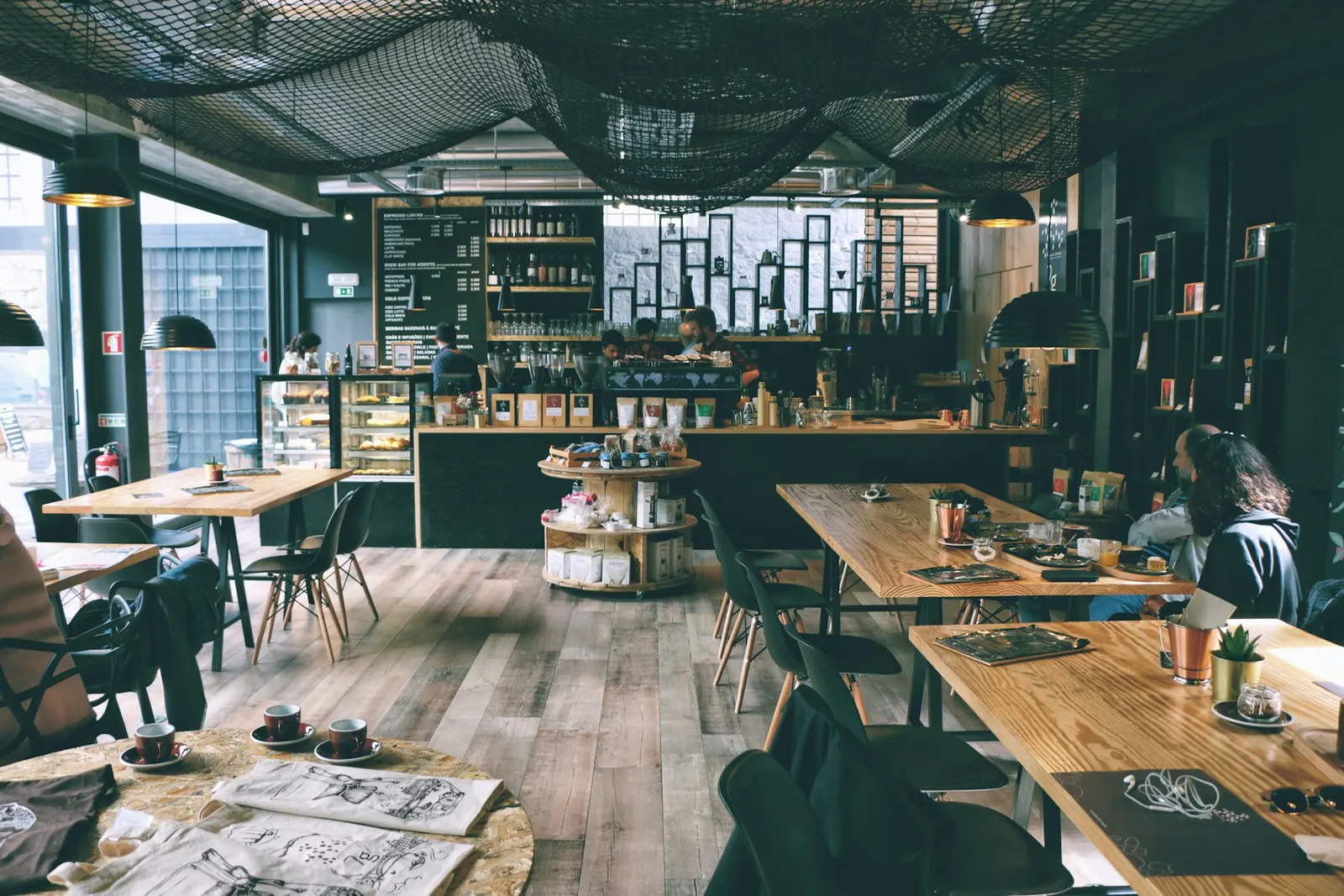 The long bar and tables at Oriel, lit by pendant lamps